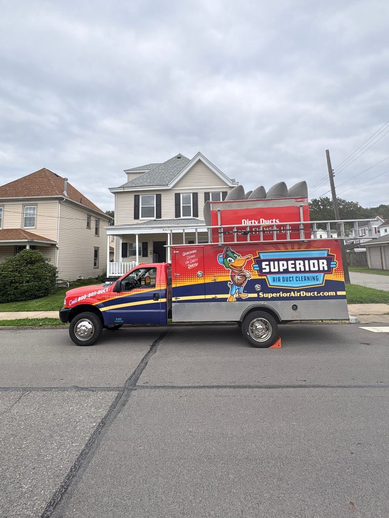 Superior Air Duct Cleaning truck parked on the street in front of a two-story home