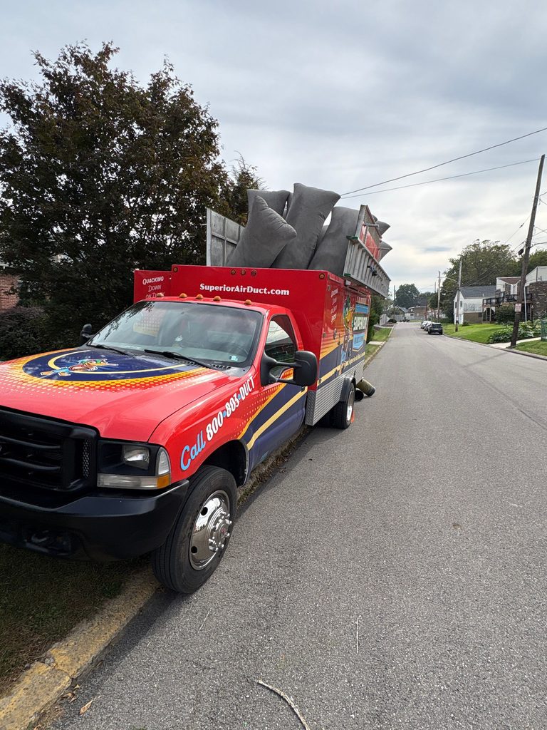 Superior duct-cleaning truck with filter bags loaded, parked on a quiet residential street