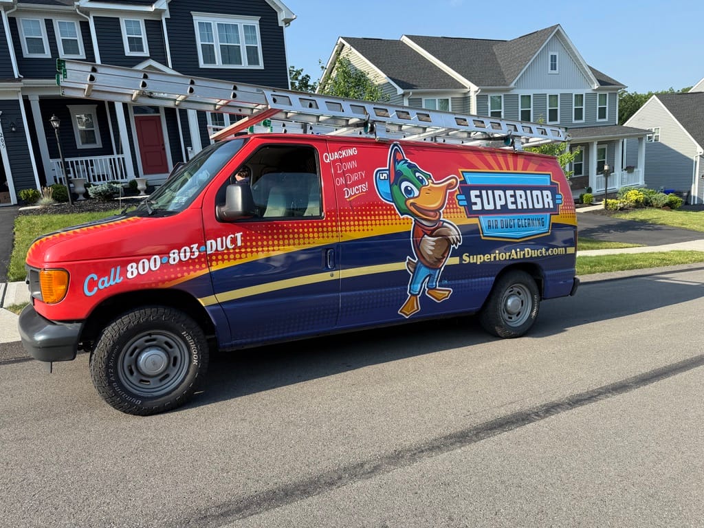 Superior's wrapped dryer vent cleaning van with roof ladder, parked on a residential street