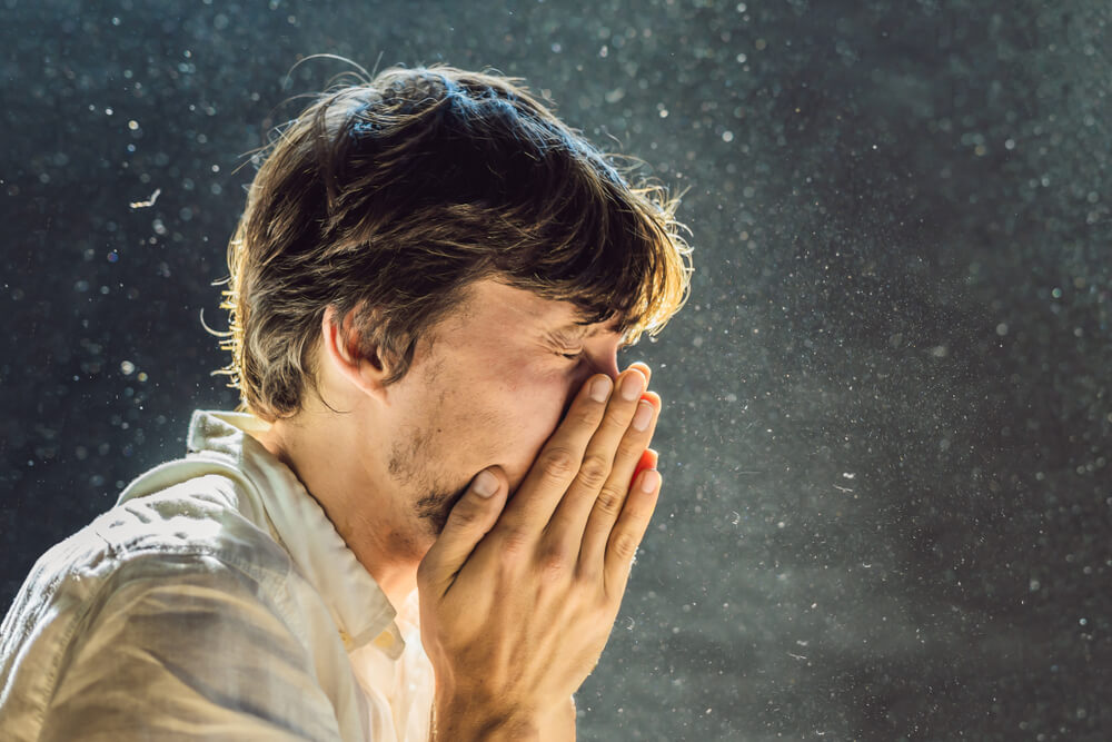 man sneezing into hands, superior duct cleaning