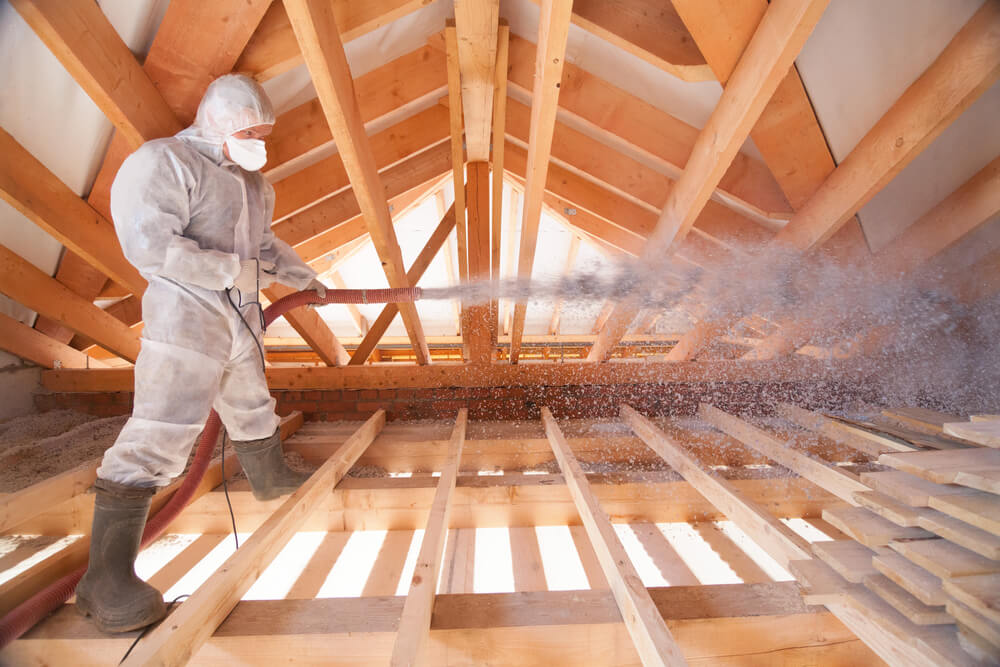 duct cleaning technician using vacuum to suction loose insulation